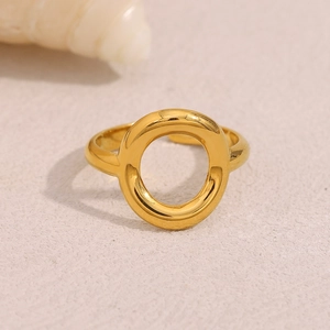Dettaglio dell'anello circolare traforato placcato oro 18K su sfondo sabbioso