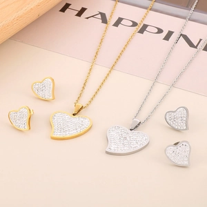 Close-up of heart necklace and earrings jewelry set in gold and silver finish