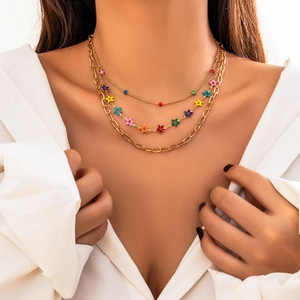 Close-up of three-layered bohemian gold necklace with colorful star enamel pendants