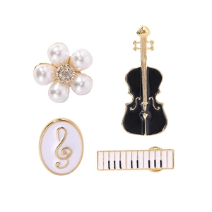 Set of four music themed brooches featuring violin, piano, notes and pearl flower