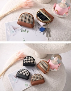 Detail of houndstooth mini coin purse showing metal zipper and inner storage for keys
