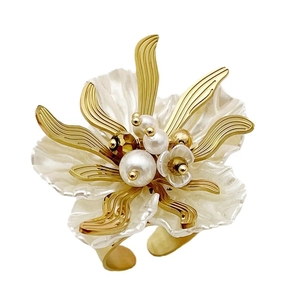 Adjustable gold ring with white flower petals and pearl centers on white background