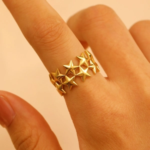 Close-up of a double-layered gold star ring on a finger with minimalist geometric style