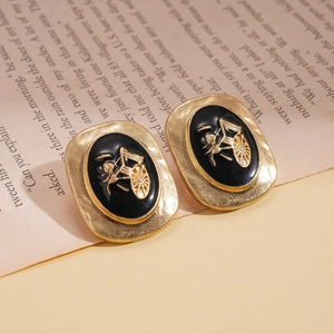 Boucles d'oreilles rétro dorées avec émail noir et motif de carrosse en relief sur livre