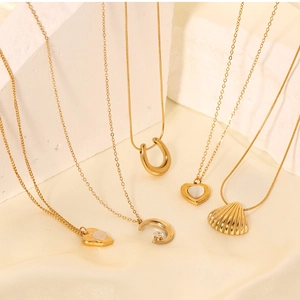 Detail of assorted gold necklaces with cat eye stone, zircon moon, and pearl smiley pendants