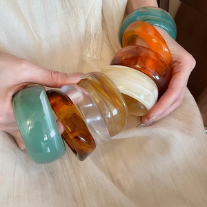 Detailed close-up of glossy multi-color acrylic resin bangles with marble texture