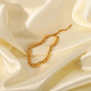 Detail of 18K gold-plated beaded bracelet featuring lobster clasp and extension chain