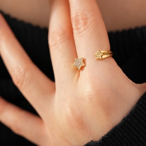 Détail d'une bague ouverte plaquée or 18k avec motifs étoiles et zircons scintillants