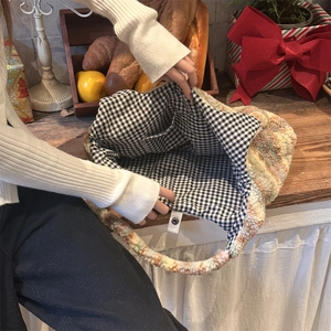 Detail of multi-color plush tote bag with magnetic closure and checkered lining interior