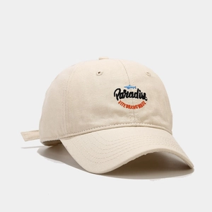 Dettaglio del berretto beige in cotone con logo Paradise ricamato e icona di pesce