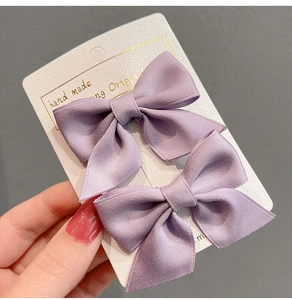 Detail of light purple handmade satin bow hair clips for girls on a display card