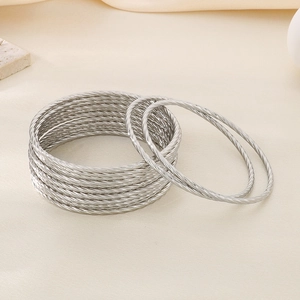 Macro detail of silver twisted metal bangles set in high-quality stackable design