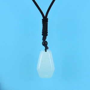 Macro shot of translucent white hexagonal crystal pendant with black braided rope cord