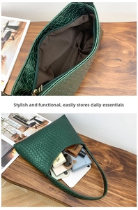 Detail view of green embossed handbag with textured surface and spacious inner compartment