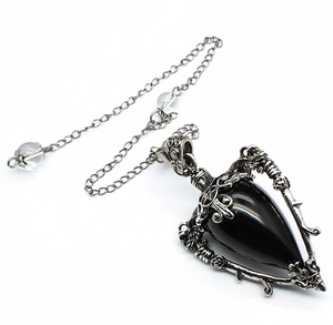 Macro view of black teardrop stone in silver gothic frame with pentagram carvings