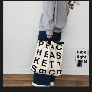 Minimalist canvas tote bag with black letter print and handles for casual daily use