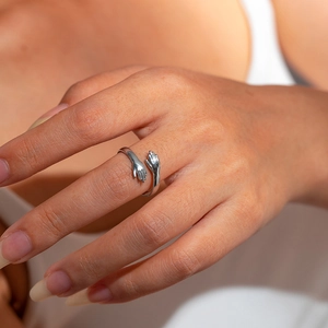 Detailed view of silver hugging hands ring in adjustable polished stainless steel