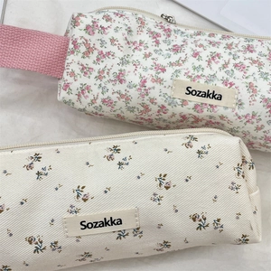 Macro view of floral canvas pencil cases showing fabric texture and sturdy zippers