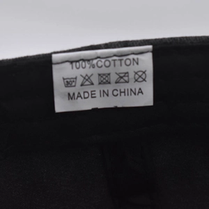 Detailed internal washing label of the 100% cotton baseball cap showing care symbols