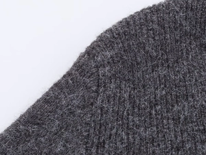 Macro shot of dark grey ribbed knit fabric texture with soft wool mohair fibers