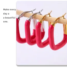 Gros plan détaillé de boucles d'oreilles en U dorées avec émail rose fuchsia