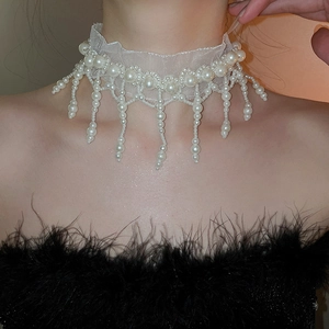 Detail of white mesh lace choker with hanging pearl tassels on model neck
