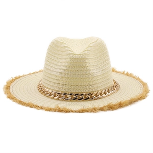 Close-up of cream raffia sun hat featuring frayed edges and a gold chain decorative band