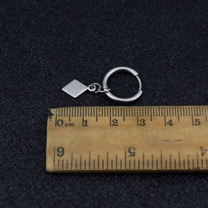 Macro view of silver square pendant earring with wood ruler showing 30mm total length