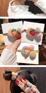Dettaglio di elastici per capelli fragola in peluche con pompon morbidi per ragazze
