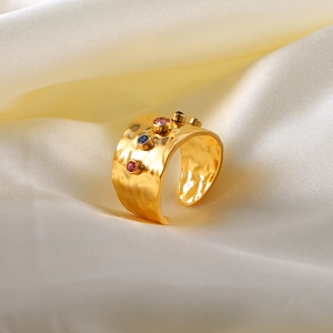 Detail of 18K gold-plated hammered ring with three colorful zircon stones on silk
