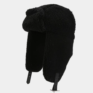 Detail of black trapper hat featuring faux fur lining and leather chin strap with metal buckle