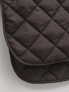 Macro view of dark brown quilted diamond pattern fabric with precise stitching and texture