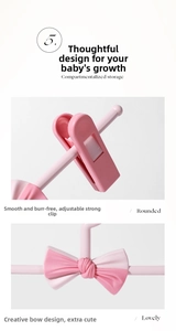 Detail of pink kids clothes hanger with adjustable non-slip clips and bow design