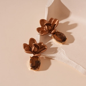 Detail of vintage flower earrings with brown matte petals and zircon gemstone drop