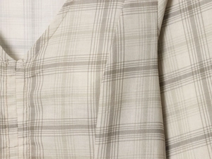 Detailed close-up of the V-neckline and plaid fabric texture of this stylish dress