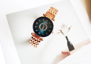 Détail d'une montre en or rose avec cadran dégradé et détails en diamants