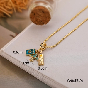 Detail of gold bead chain with green airplane, blue passport, and suitcase charms