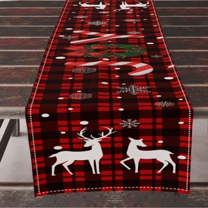 Christmas table runner with red and black plaid pattern, reindeer and snowflakes on wood