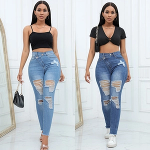 Detail view of high-waisted distressed denim shorts with cross-button waist in two blue washes