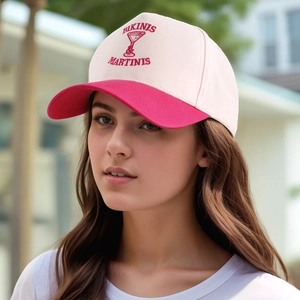 Detail of vintage beige baseball cap with pink brim and red BIKINIS MARTINIS embroidery