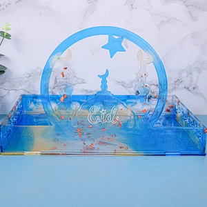 Close-up of blue resin Eid tray with gold foil flakes and crescent moon arch