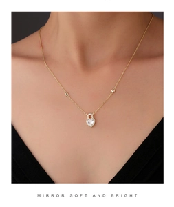Detailed view of an elegant gold heart-shaped pendant necklace worn by a female model