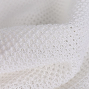 Gros plan sur la texture du tricot ajouré blanc avec structure en maille aérée