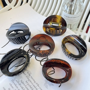 Minimalist oval shark hair clips set in black and amber tortoise shell resin for women