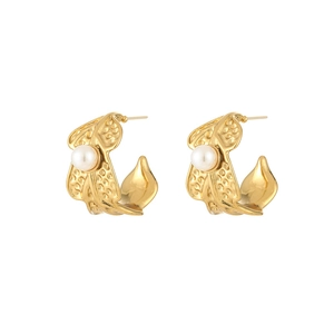 Close-up of golden C-shaped pearl earrings with hammered texture in French vintage style