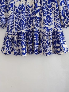 Close-up of bohemian blue floral print dress featuring ruffled hem and textured fabric