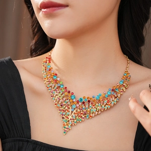 Detail of vintage layered V-shaped necklace with colorful rhinestones on a gold base