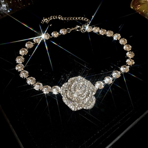 Detailed shot of vintage silver rose pendant with zircon on black velvet with star flare
