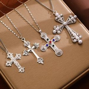 Detailed view of layered silver cross necklaces with gothic and gemstone pendants