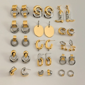 Mise à plat de boucles d'oreilles minimalistes modernes avec finitions or et argent polies